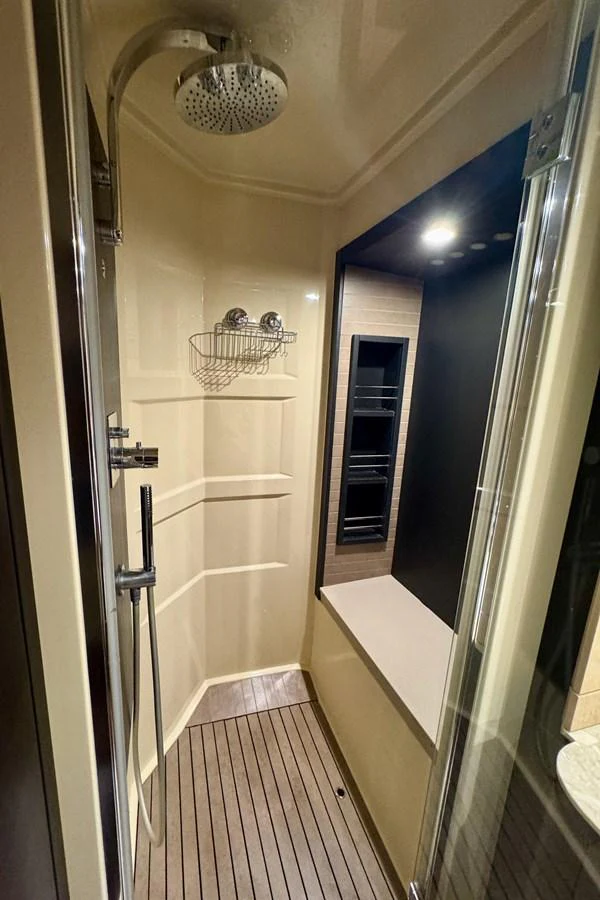 The image showcases a modern and compact yacht shower with sleek fixtures and a wooden floor. aboard KIKI Yacht for Sale