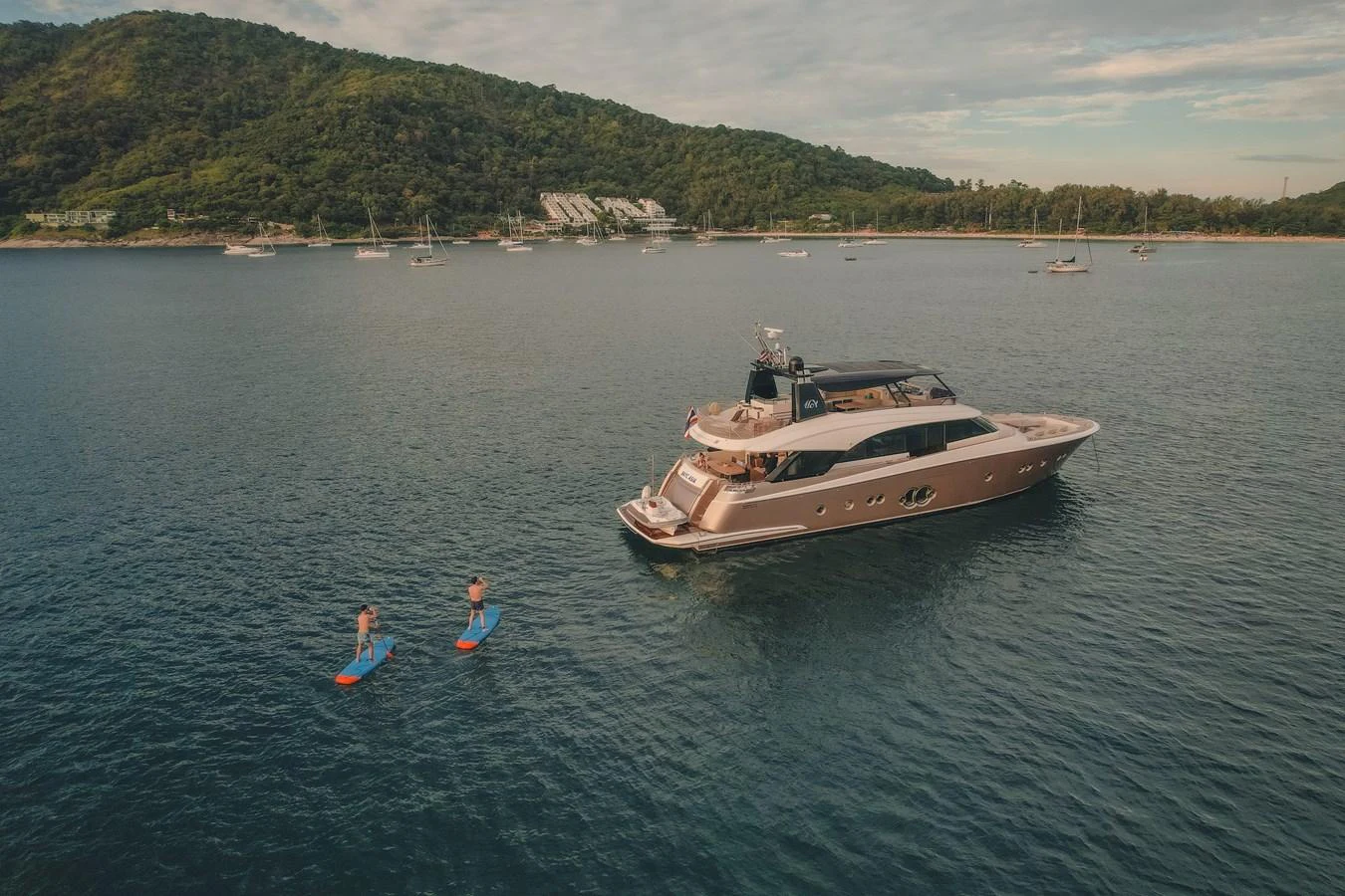 a man and a woman in the water next to a boat aboard MOANA Yacht for Sale