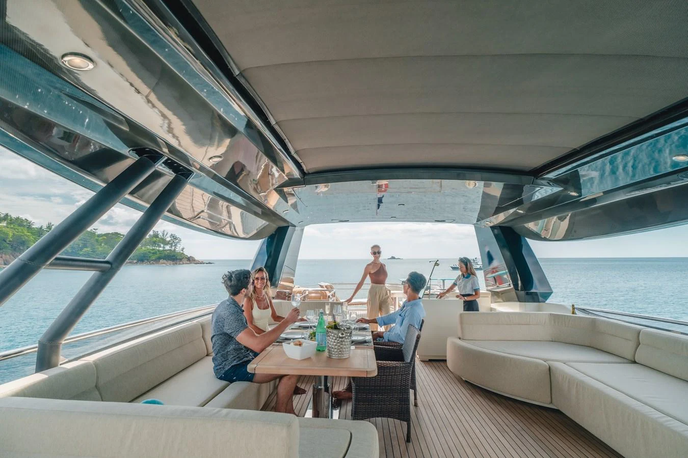 a group of people sitting around a table on a boat aboard MOANA Yacht for Sale