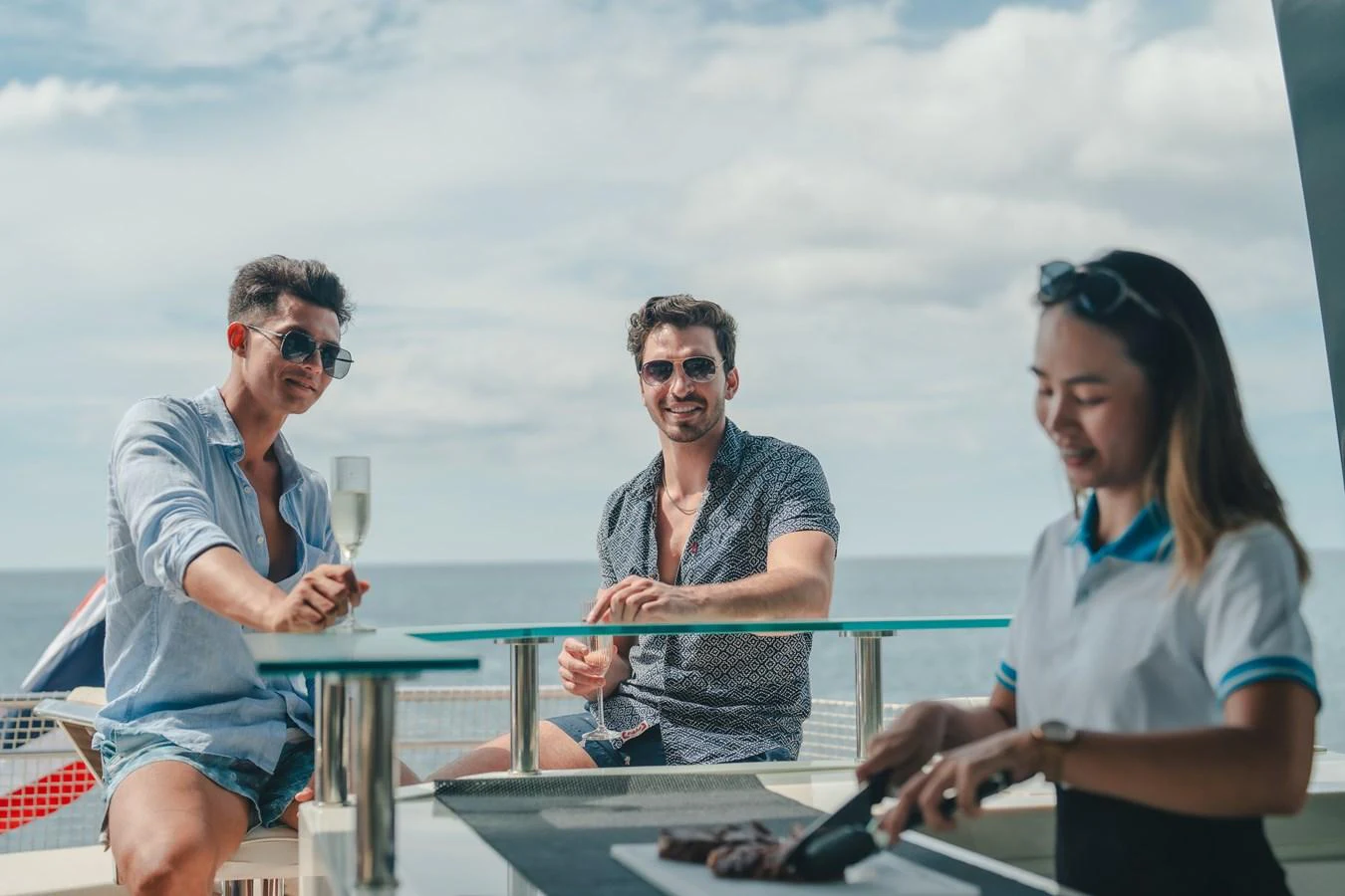 a group of people sitting at a table outside aboard MOANA Yacht for Sale