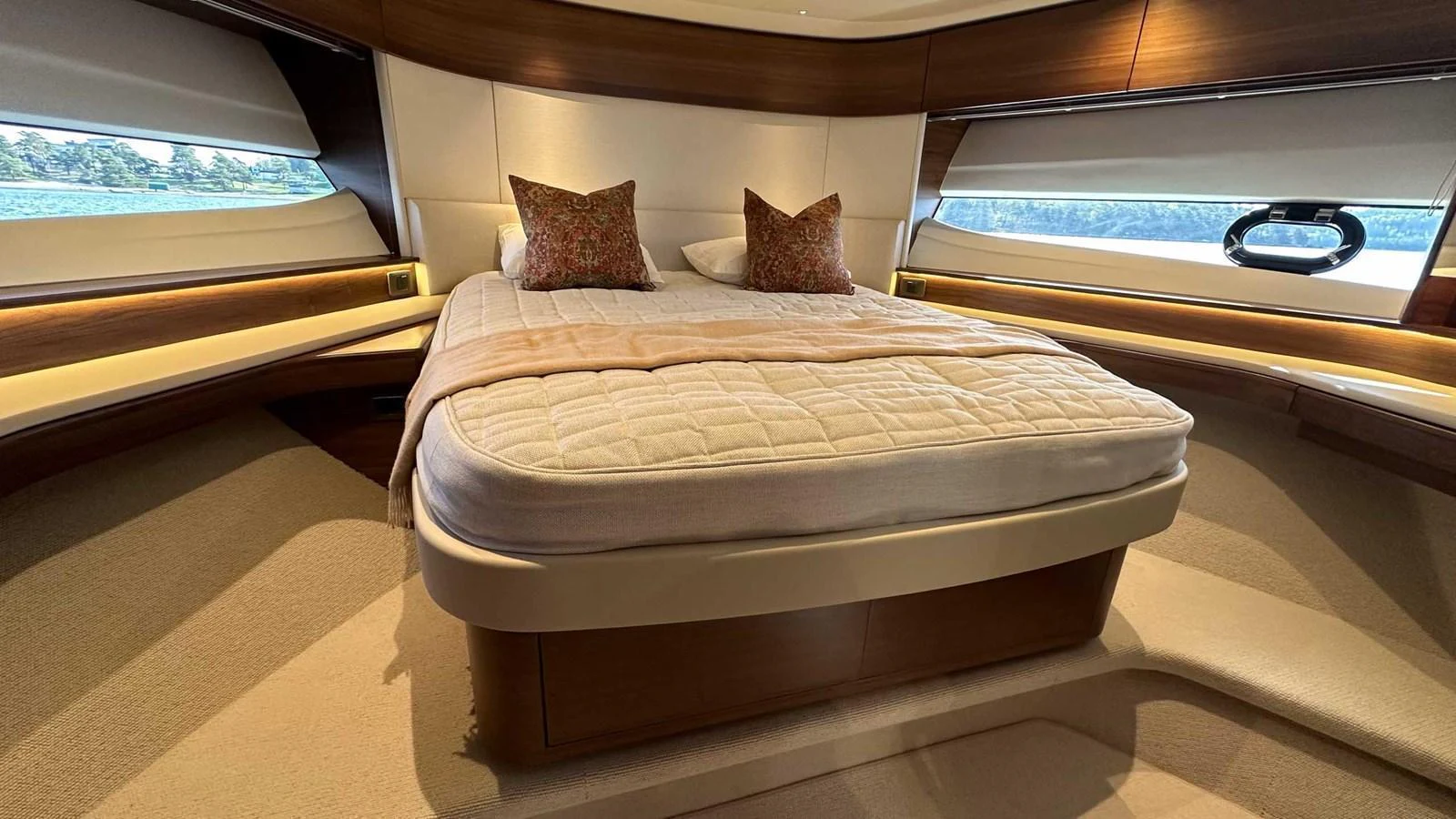 The master stateroom features a luxurious bed with elegant bedding and ample natural light from large windows. aboard PRINCESS F65 Yacht for Sale