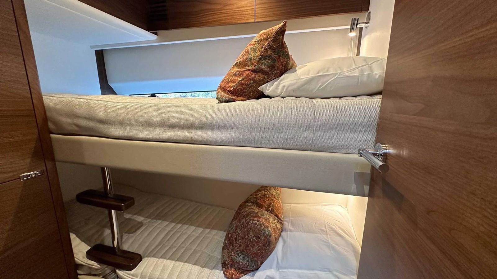 The cozy bunk cabin features comfortable bedding and warm wooden accents. aboard PRINCESS F65 Yacht for Sale