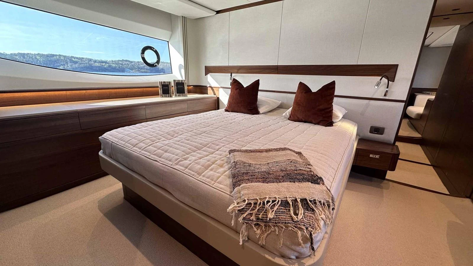 A luxurious stateroom featuring a large bed with elegant bedding and a scenic window view. aboard PRINCESS F65 Yacht for Sale