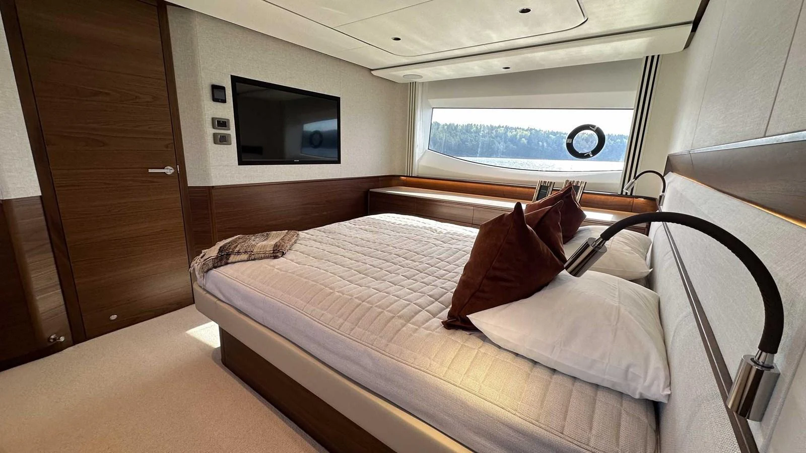 The stateroom features a luxurious bed with plush pillows and a large window offering scenic views. aboard PRINCESS F65 Yacht for Sale