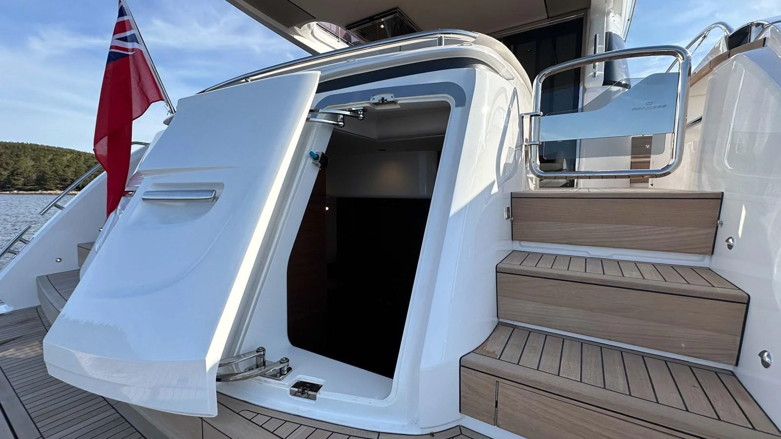 A close-up view of a yacht's entryway with an open hatch and adjacent stairs. aboard PRINCESS F65 Yacht for Sale