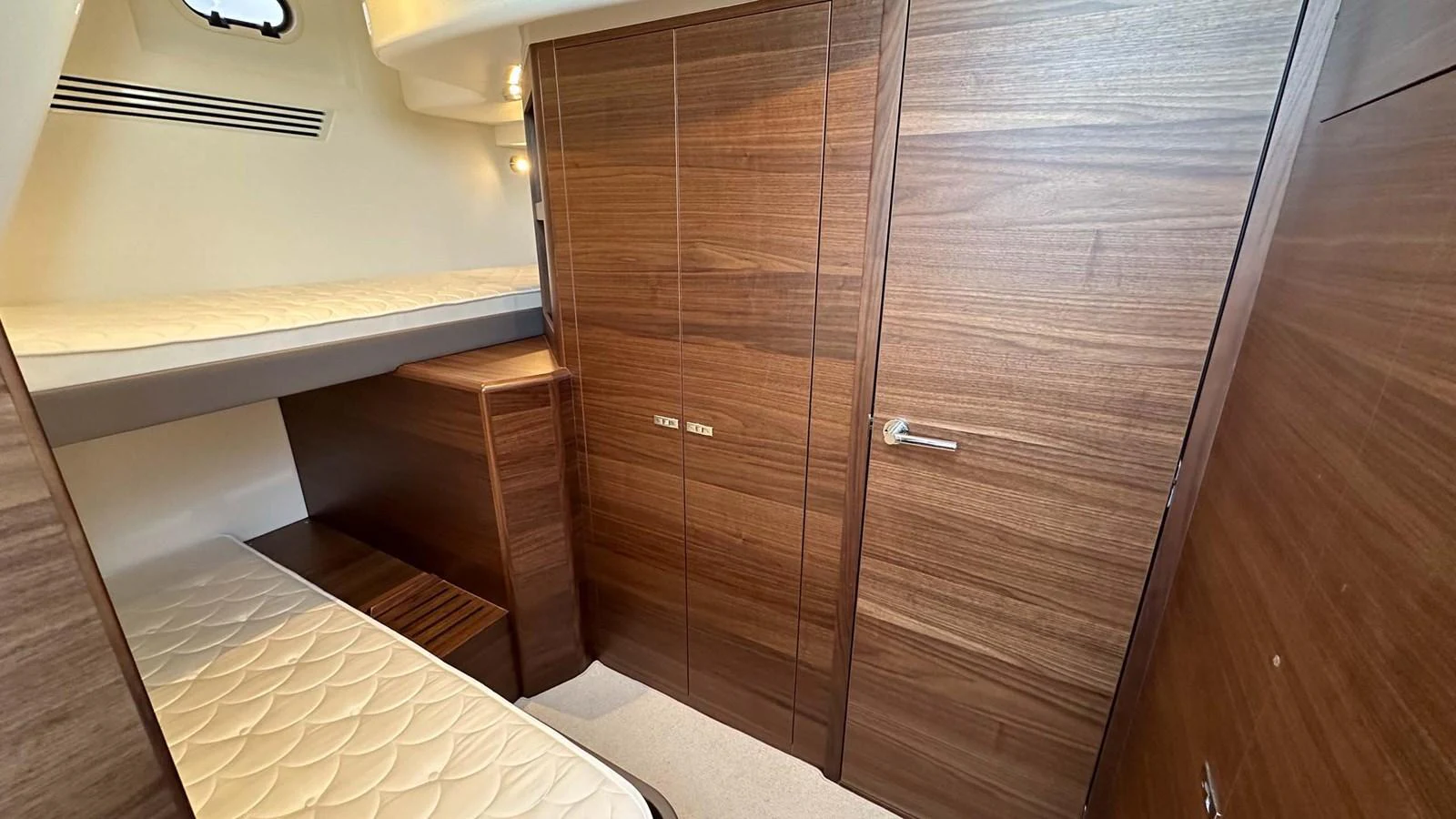 The cabin features sleek wooden finishes and comfortable bedding, creating a cozy and inviting space. aboard PRINCESS F65 Yacht for Sale
