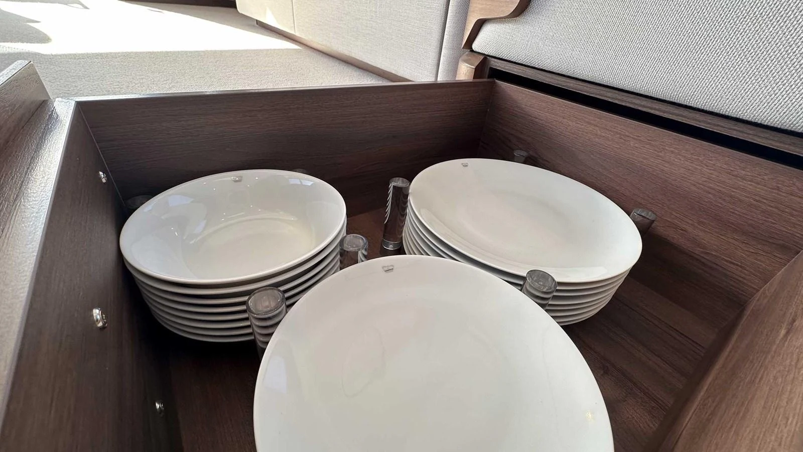 A neatly organized drawer with stacked white plates showcases the yacht's attention to detail and functionality. aboard PRINCESS F65 Yacht for Sale