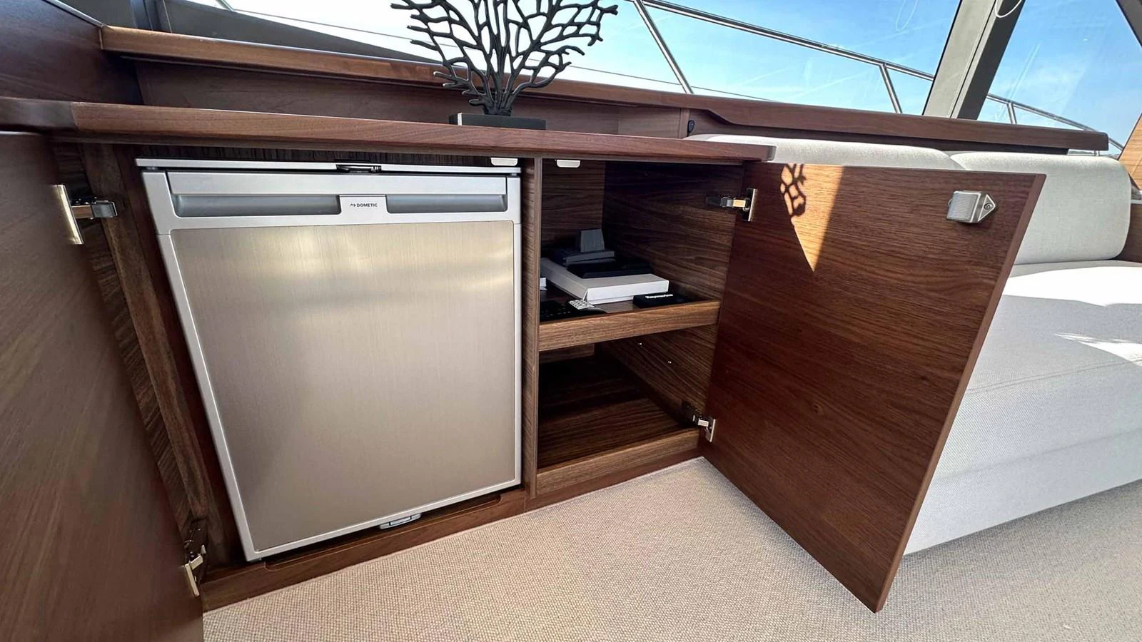 The yacht's interior features a sleek built-in refrigerator and ample storage space with wooden cabinetry. aboard PRINCESS F65 Yacht for Sale