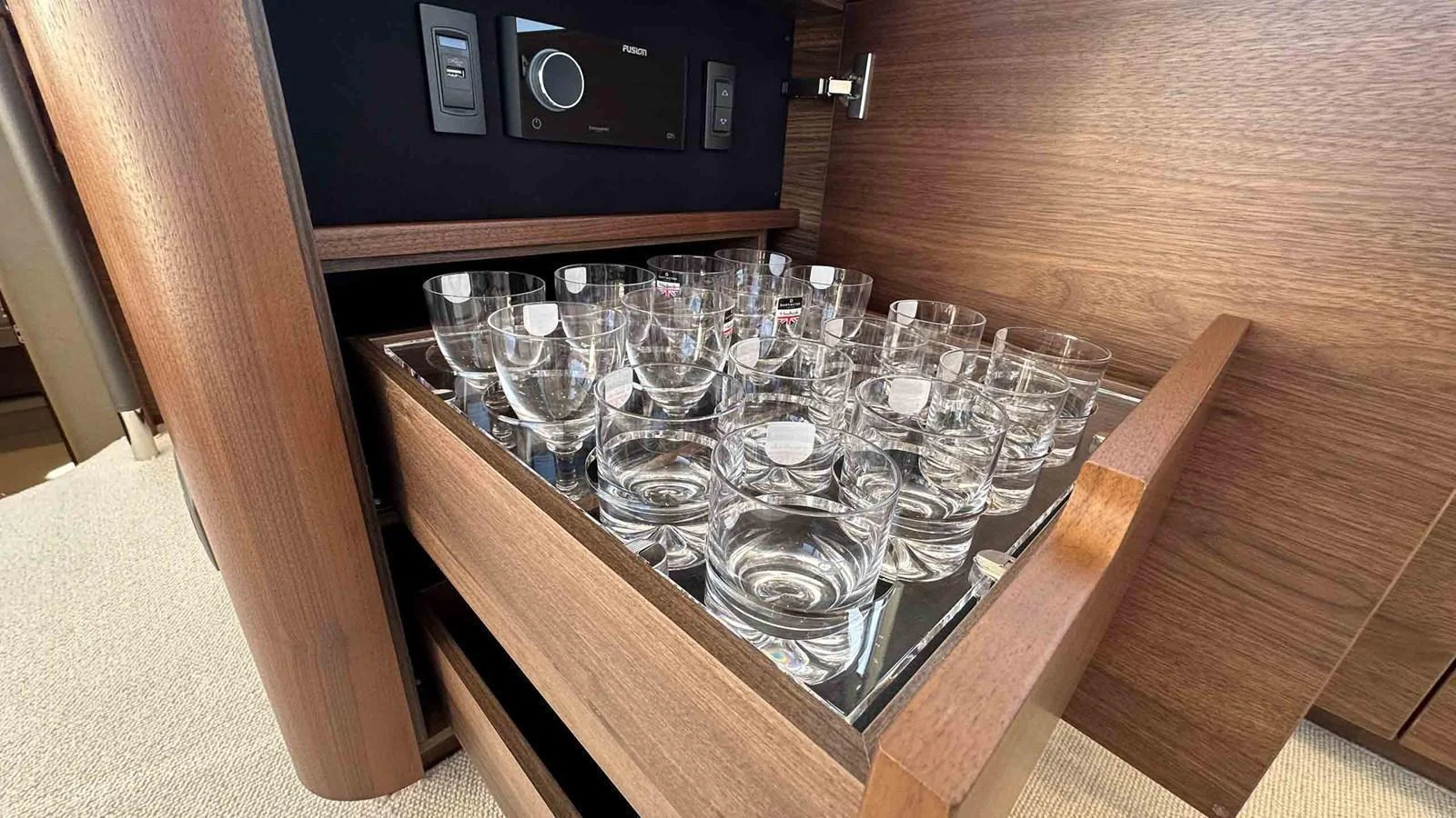 A drawer filled with neatly arranged glassware, showcasing the yacht's attention to detail and luxury. aboard PRINCESS F65 Yacht for Sale
