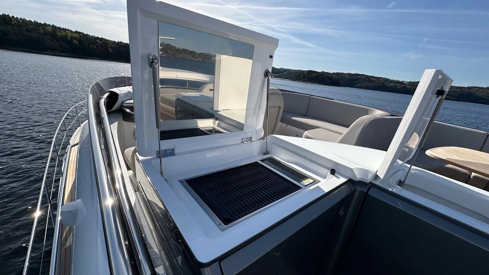 A close-up view of a yacht's deck with an open hatch and seating area in the background. aboard PRINCESS F65 Yacht for Sale