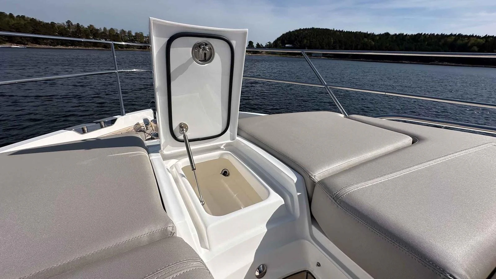The image showcases a sleek and modern deck detail with comfortable sun pads and a built-in storage compartment. aboard PRINCESS F65 Yacht for Sale