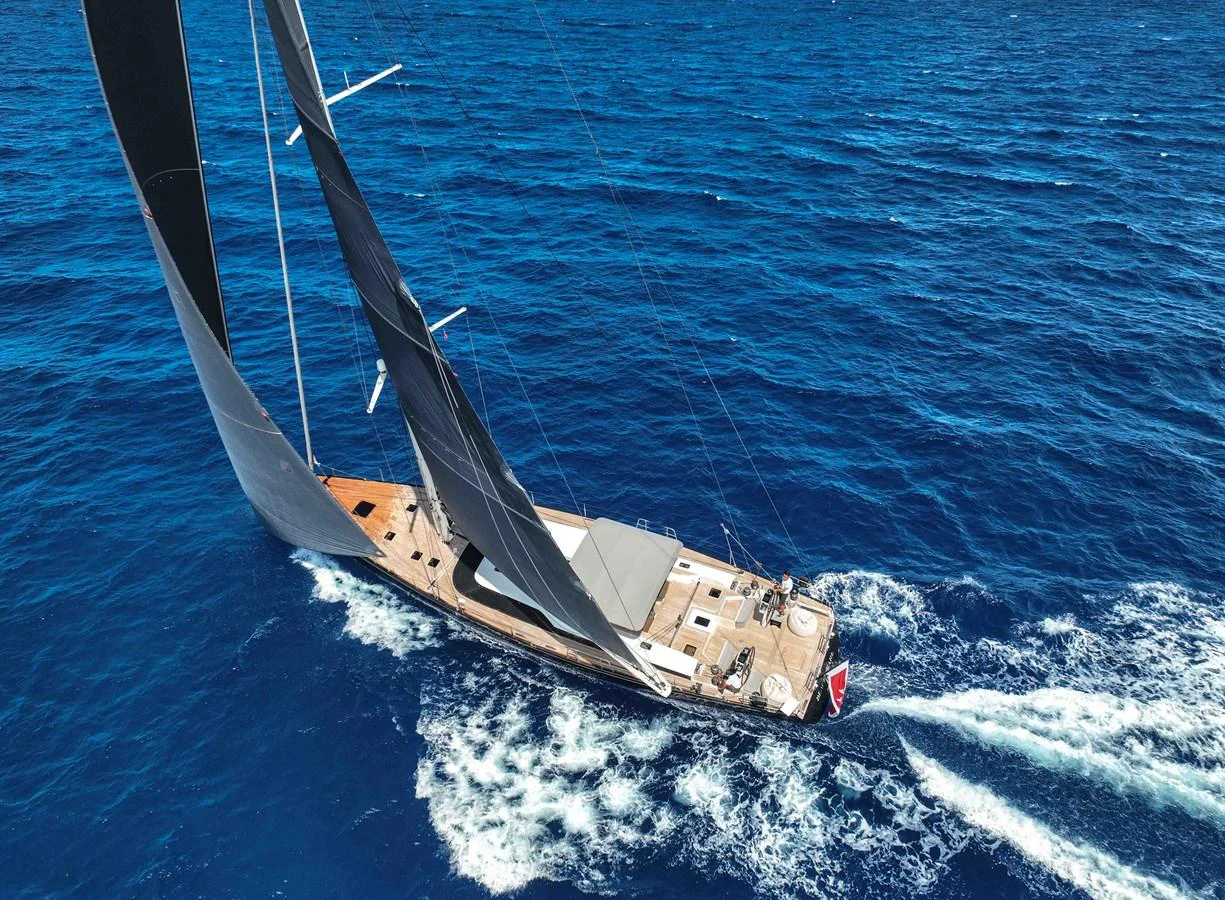 A sleek sailing yacht glides gracefully over the vibrant blue sea. aboard BLACK PEARL II Yacht for Sale