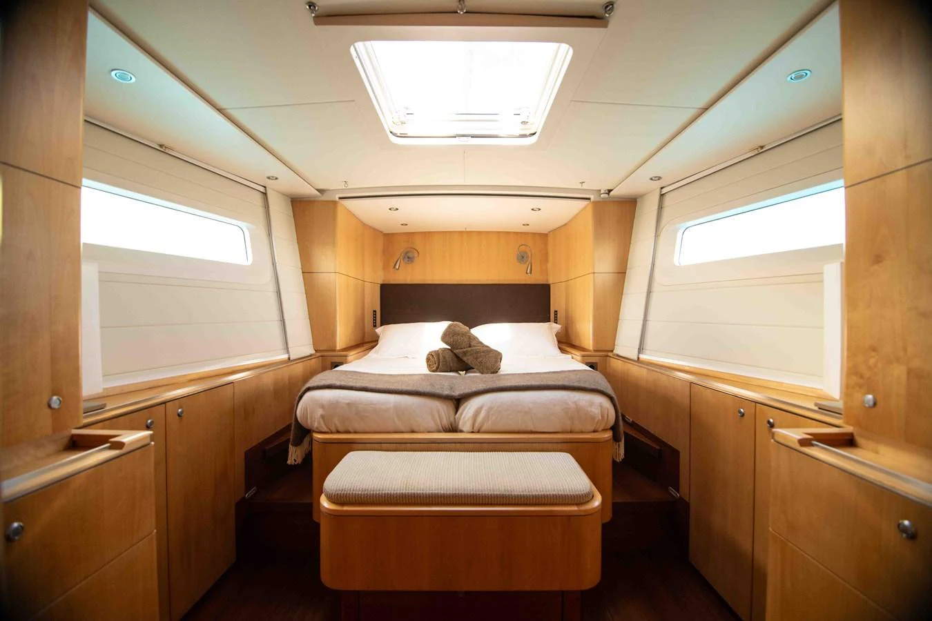 The stateroom features a cozy double bed with natural light streaming in from the side windows and overhead hatch. aboard BLACK PEARL II Yacht for Sale