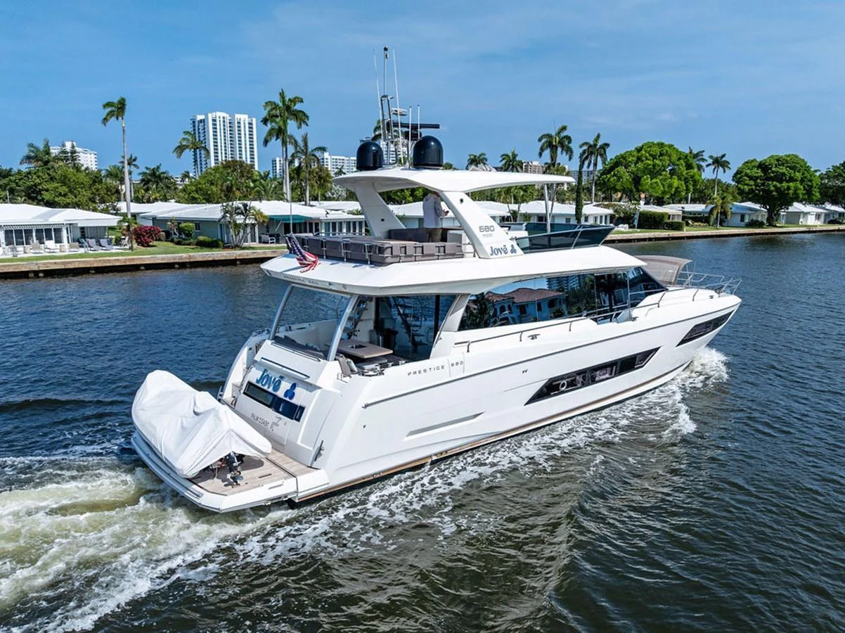 A sleek and modern yacht cruises through calm waters, showcasing its elegant design and spacious deck areas. aboard JOVE Yacht for Sale