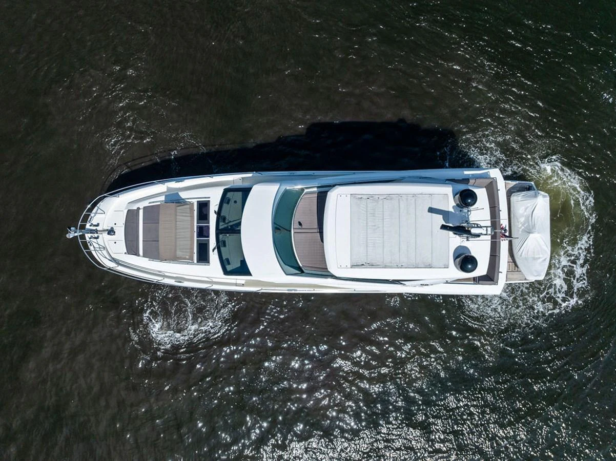 A sleek yacht glides smoothly through the water, showcasing its elegant design from an aerial perspective. aboard JOVE Yacht for Sale