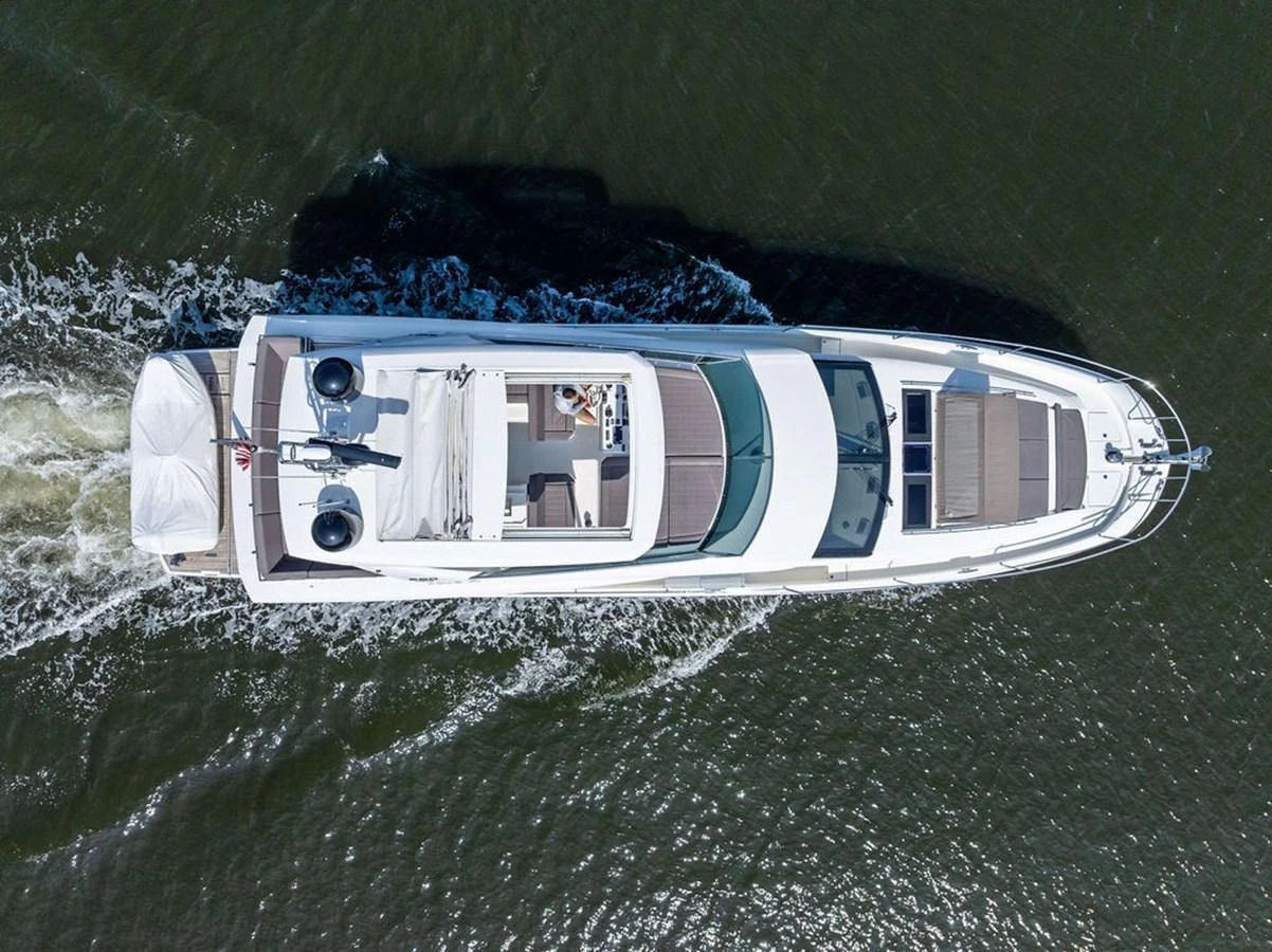 An aerial view of a sleek yacht cruising through the water, showcasing its spacious deck and modern design. aboard JOVE Yacht for Sale