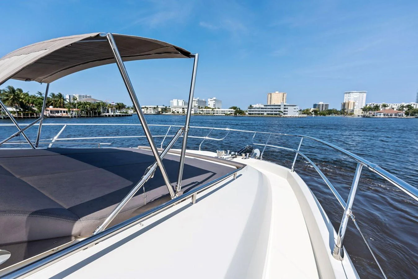 The yacht's bow offers a spacious sunbathing area with a stunning view of the water and cityscape. aboard JOVE Yacht for Sale