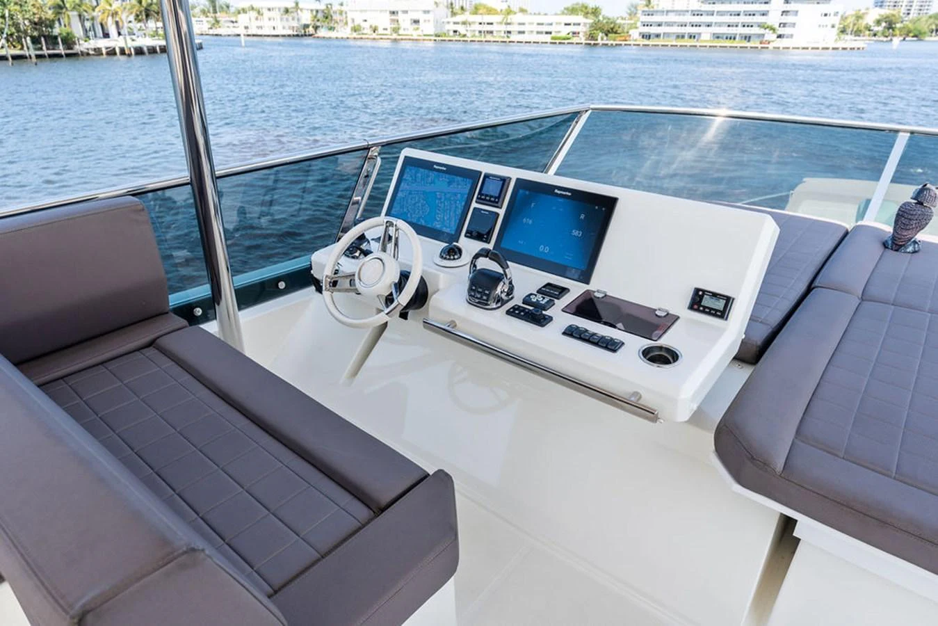 The helm station features modern navigation equipment and comfortable seating with a scenic water view. aboard JOVE Yacht for Sale