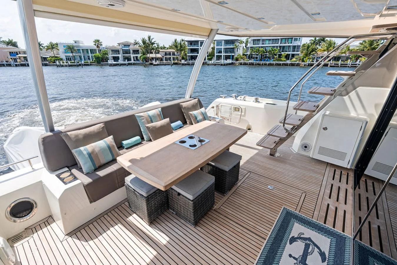 The aft deck features a comfortable seating area with a dining table, perfect for enjoying meals with a view of the water. aboard JOVE Yacht for Sale