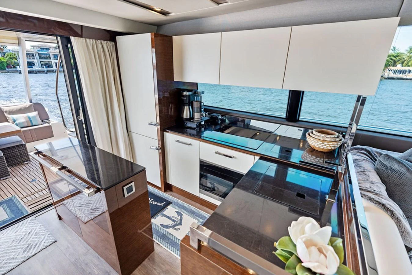 The yacht's galley features modern appliances, sleek cabinetry, and a beautiful view through large windows. aboard JOVE Yacht for Sale