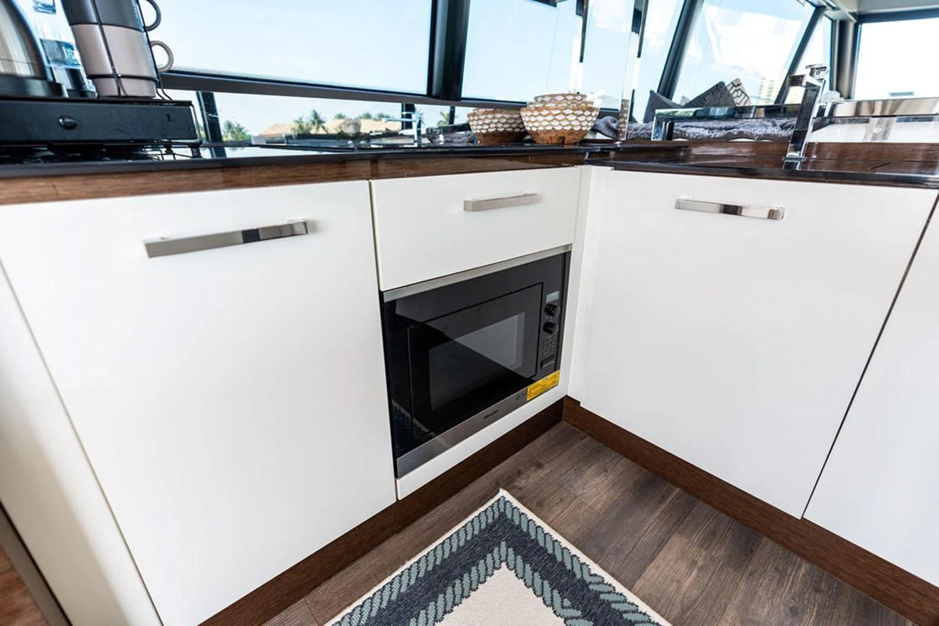 The modern galley features sleek cabinetry and a built-in microwave, perfect for onboard culinary adventures. aboard JOVE Yacht for Sale