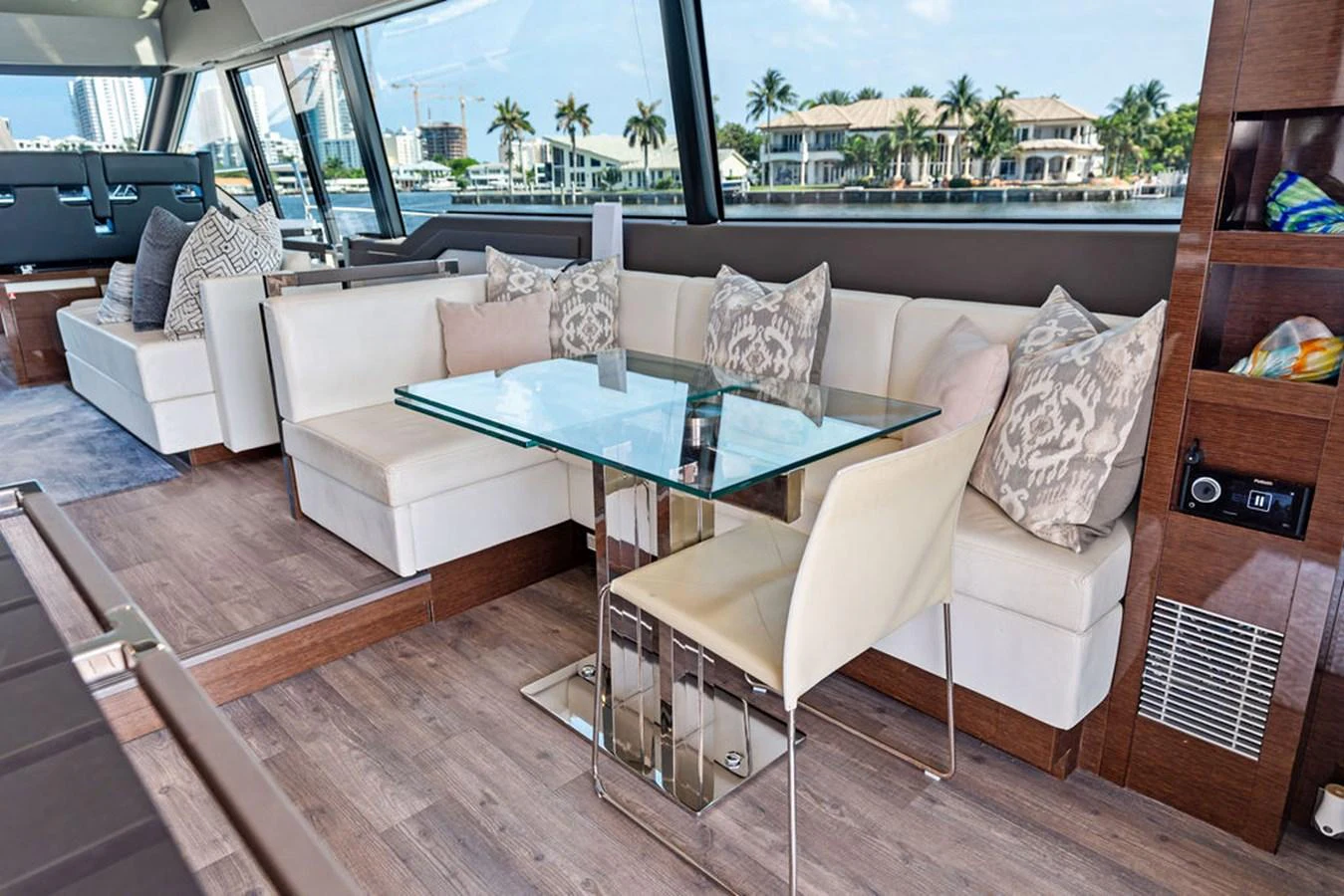 The salon features a stylish and comfortable seating area with a glass dining table, offering a luxurious space to relax and dine. aboard JOVE Yacht for Sale