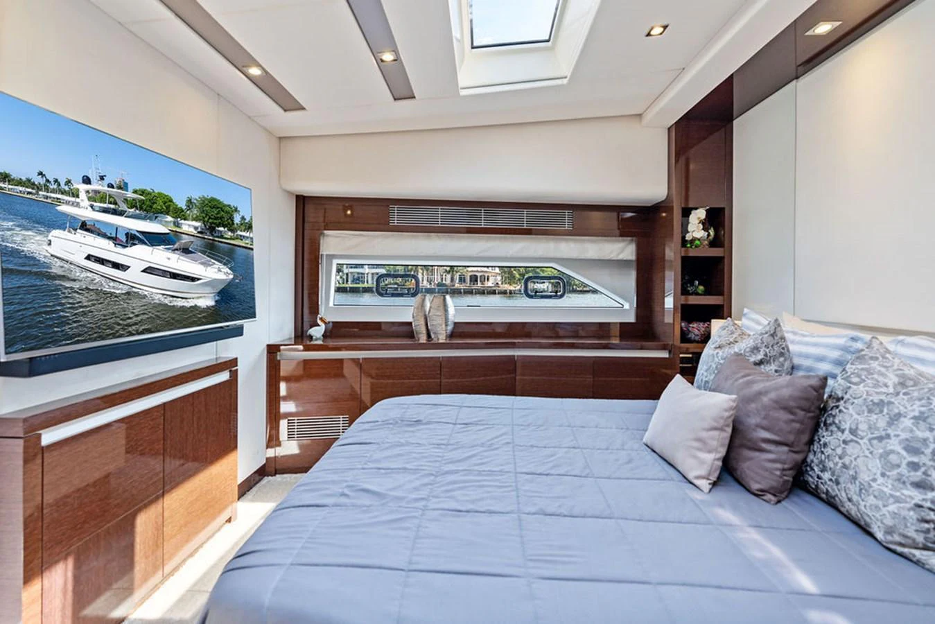 The stateroom features a spacious bed, large windows, and a flat-screen TV for ultimate comfort and relaxation. aboard JOVE Yacht for Sale