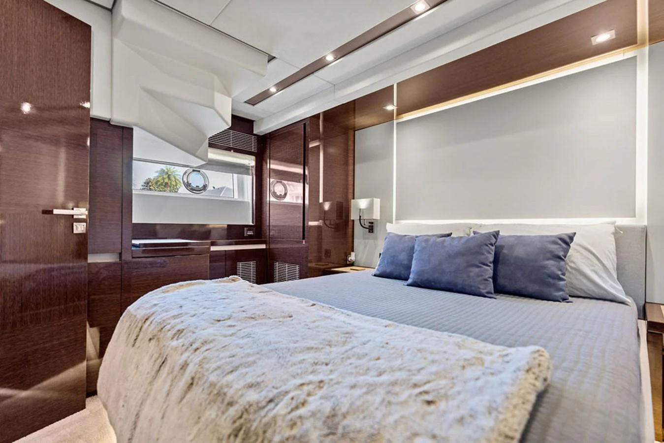 The stateroom features a plush bed with luxurious bedding and modern wood paneling. aboard JOVE Yacht for Sale