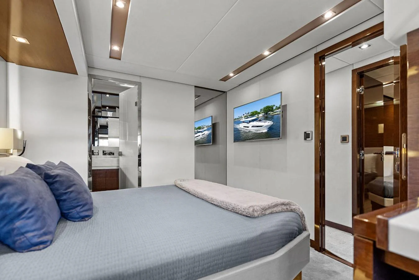 The stateroom features a comfortable bed with plush pillows and modern amenities, including a flat-screen TV. aboard JOVE Yacht for Sale