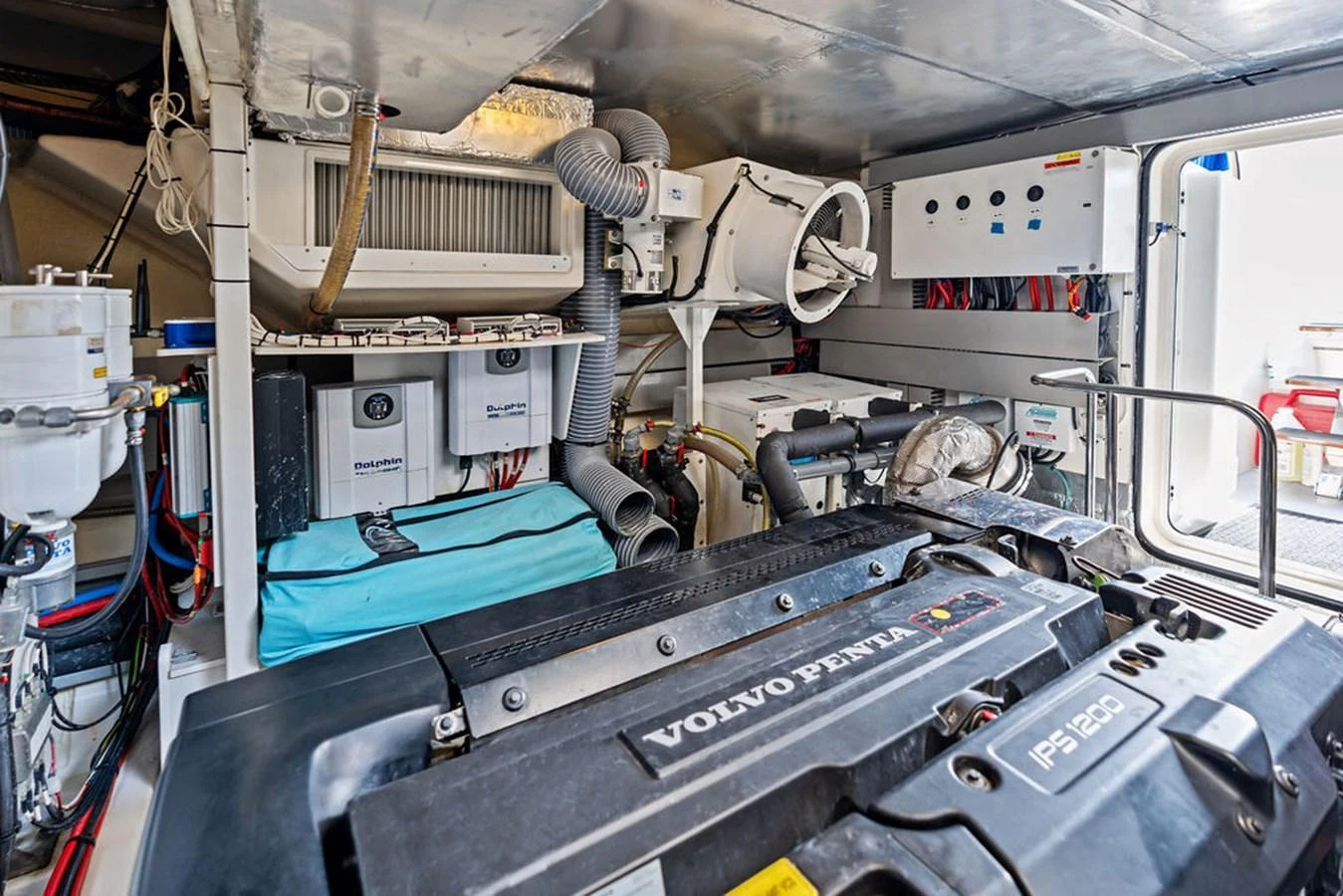 The image showcases a well-organized engine room with a Volvo Penta engine and various mechanical components. aboard JOVE Yacht for Sale