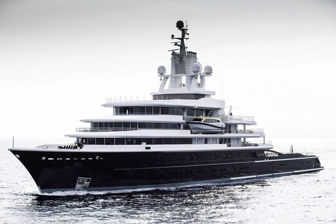 A sleek and modern yacht cruising on calm waters, showcasing its impressive multi-deck structure. aboard LUNA Yacht for Sale