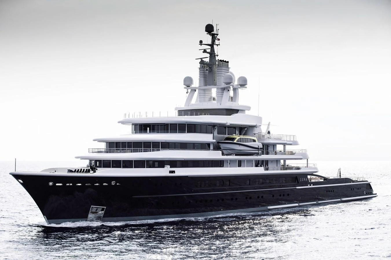 A sleek and modern yacht cruising on calm waters, showcasing its impressive multi-deck structure. aboard LUNA Yacht for Sale