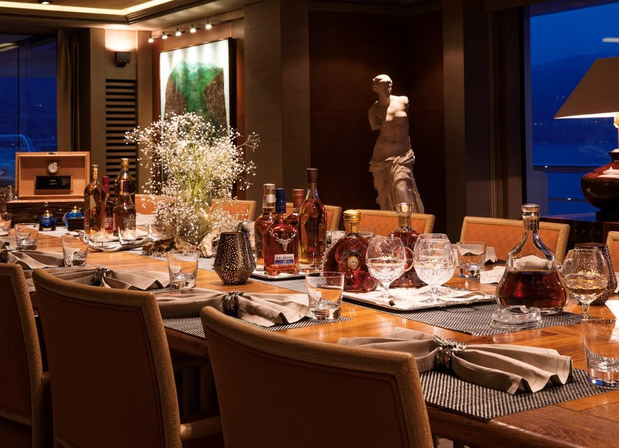 The yacht's dining area exudes elegance with a beautifully set table and ambient lighting. aboard LUNA Yacht for Sale