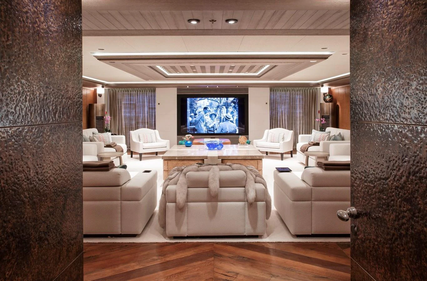 The yacht's salon features luxurious seating and a large entertainment screen, creating an inviting space for relaxation and socializing. aboard LUNA Yacht for Sale