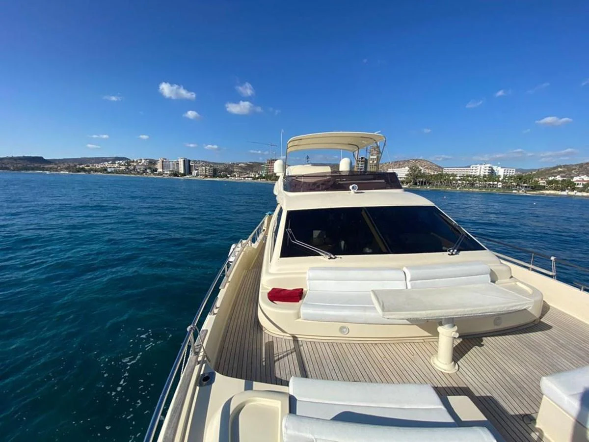 A luxurious yacht cruising on a serene blue sea with a clear sky backdrop. aboard CARAMEL Yacht for Sale