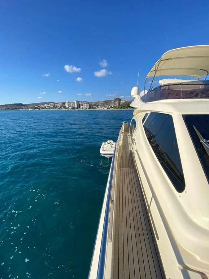 The yacht cruises along the coastline, showcasing its sleek design and luxurious deck. aboard CARAMEL Yacht for Sale