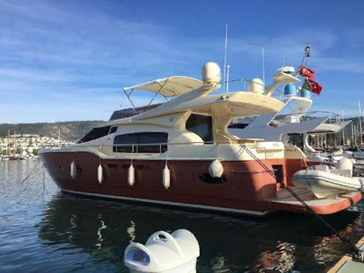 A luxurious yacht is docked at a marina, showcasing its sleek design and spacious decks. aboard CARAMEL Yacht for Sale