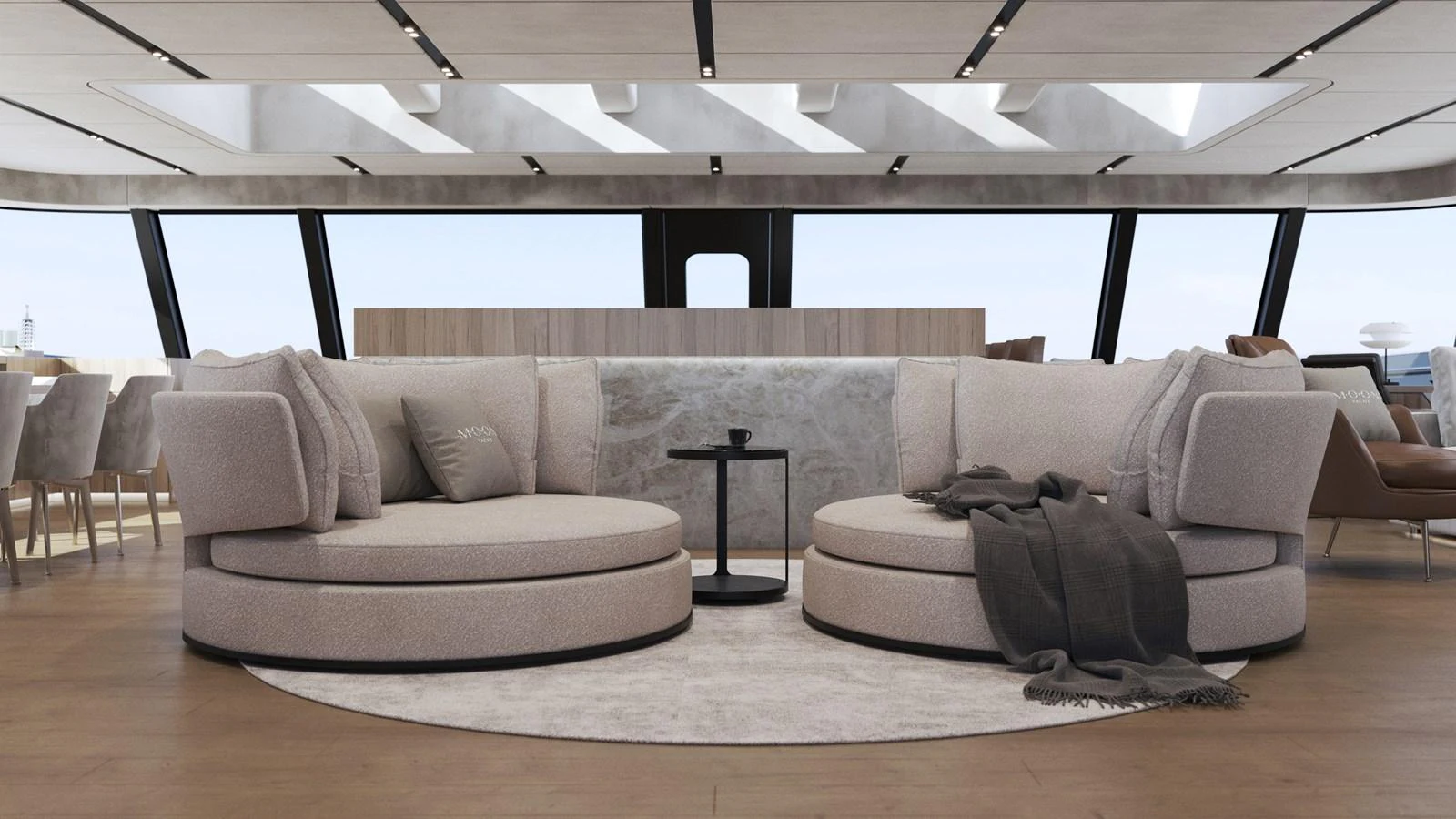 The salon features plush circular seating with a modern, open design and ample natural light. aboard 2027 MOON YACHT 100 SAIL Yacht for Sale