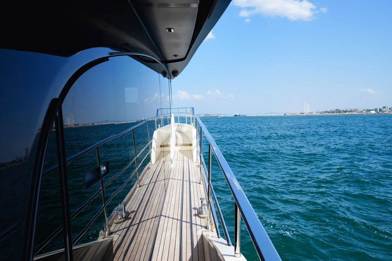 The yacht's sleek side deck offers a stunning view of the open sea under a clear blue sky. aboard AMY Yacht for Sale
