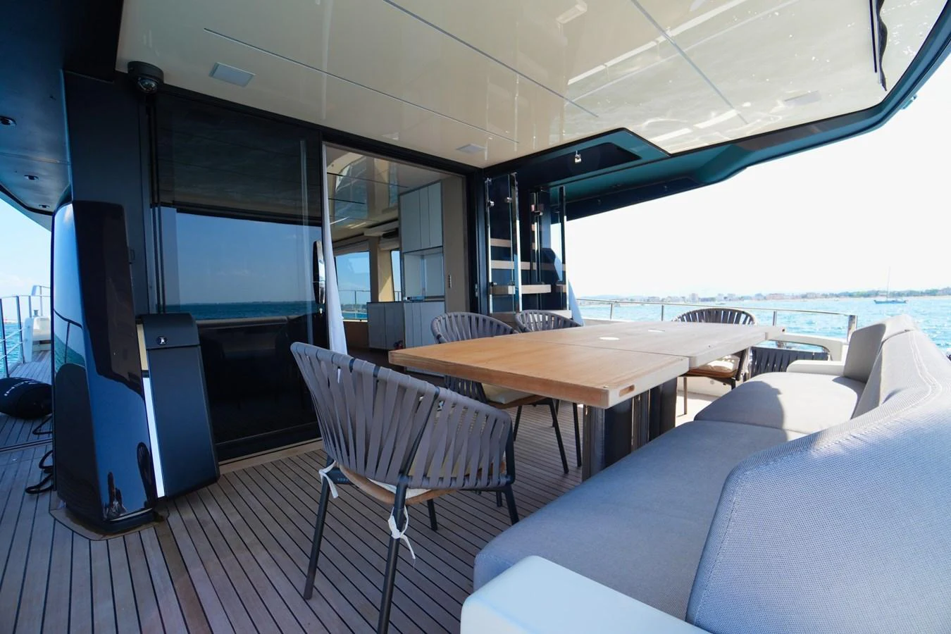 The aft deck features a spacious seating area with a wooden dining table, perfect for alfresco dining. aboard AMY Yacht for Sale