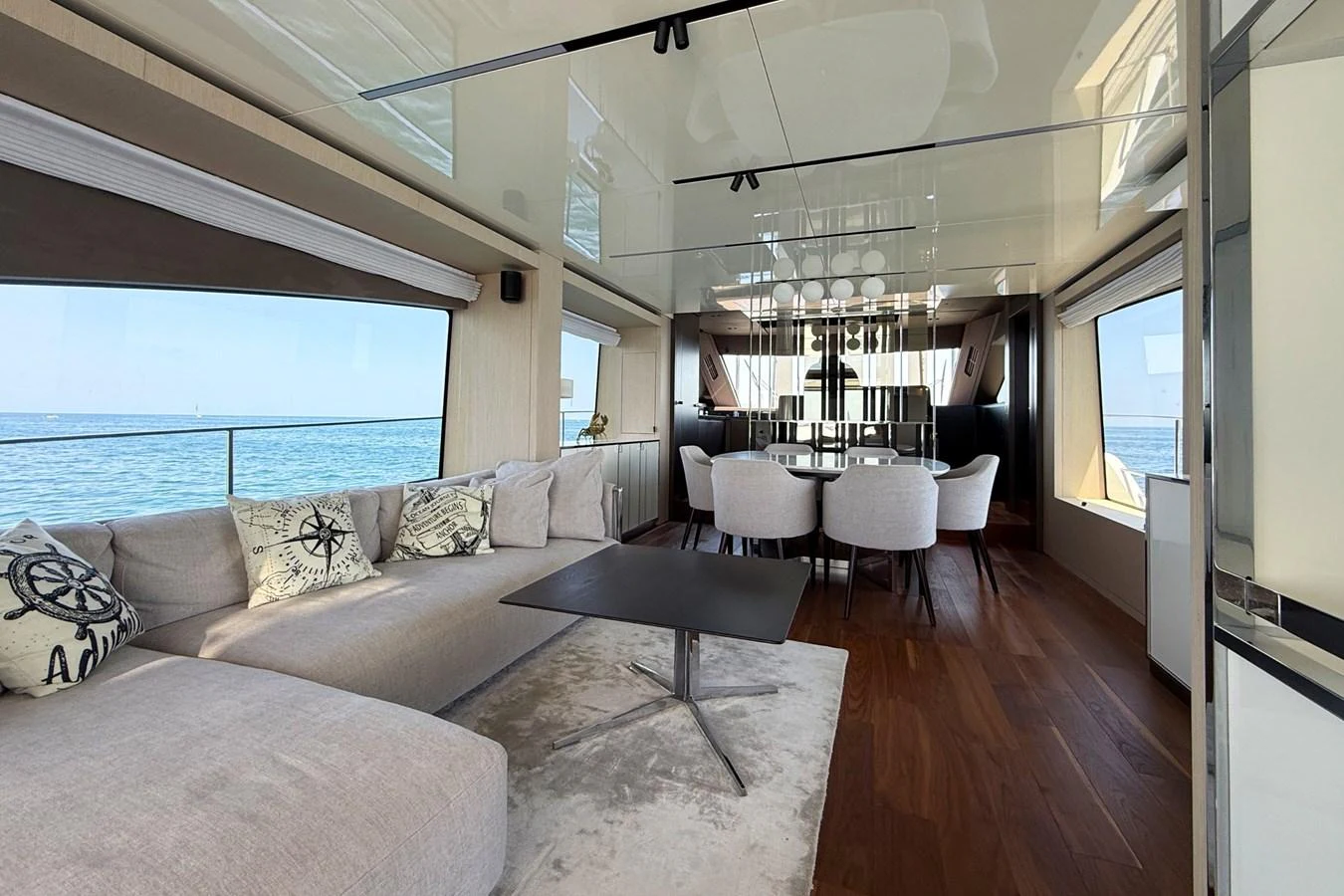 The salon features a spacious seating area with panoramic windows offering stunning ocean views. aboard AMY Yacht for Sale