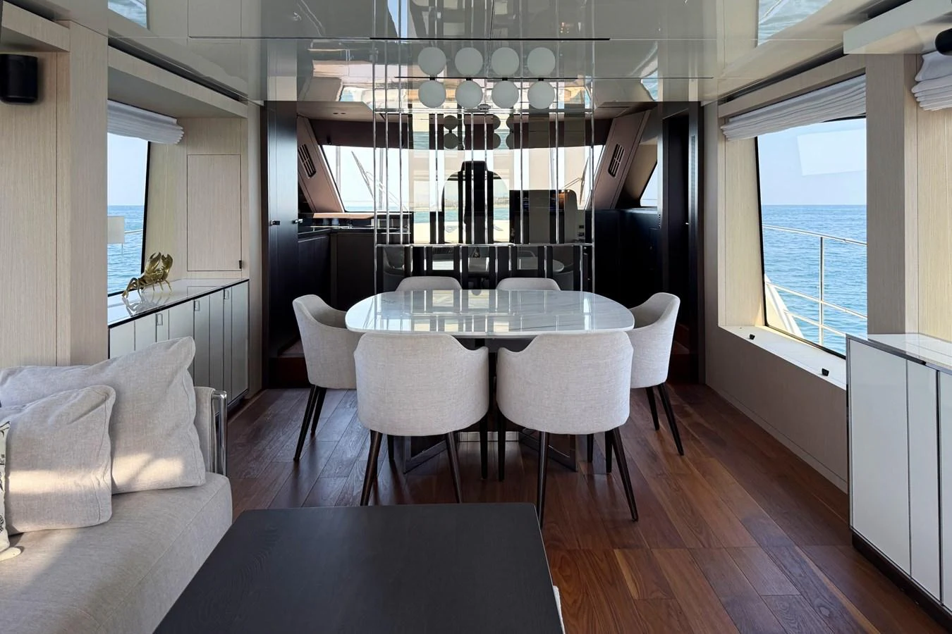 The yacht's dining area features a modern table with comfortable seating and large windows offering stunning ocean views. aboard AMY Yacht for Sale