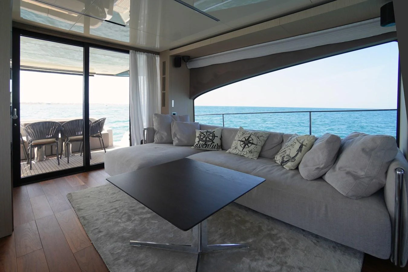 The salon offers a comfortable seating area with a view of the ocean through large windows. aboard AMY Yacht for Sale
