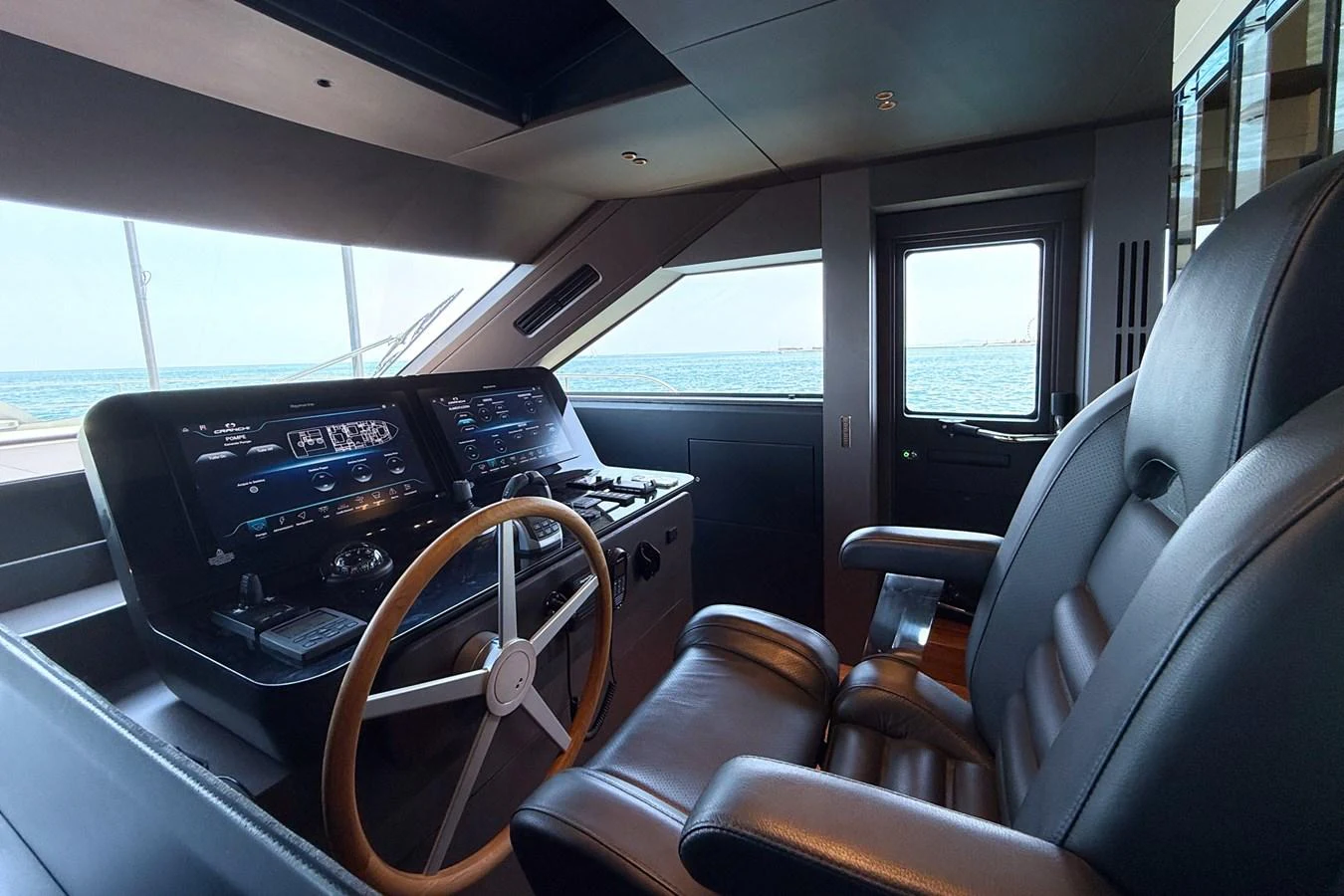 The helm station features modern navigation equipment and luxurious seating with a view of the open sea. aboard AMY Yacht for Sale