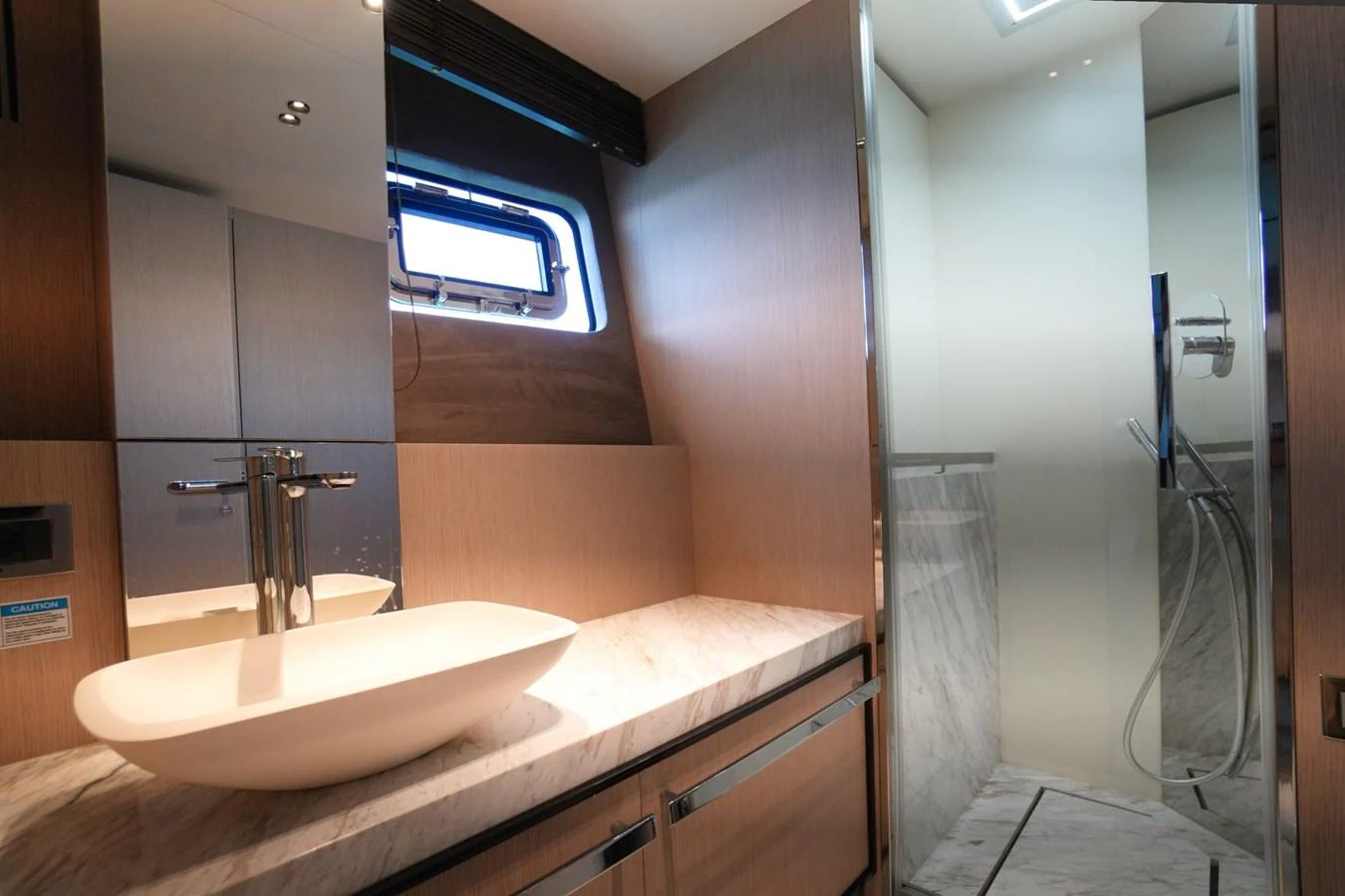 The yacht's bathroom features a modern sink and a spacious shower area with elegant finishes. aboard AMY Yacht for Sale