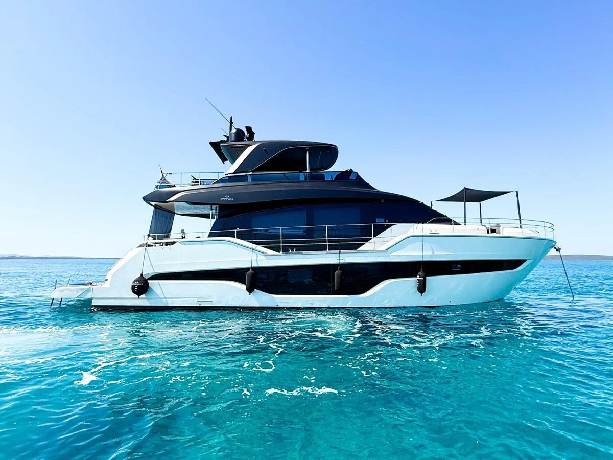 A sleek and modern yacht glides effortlessly on clear blue waters under a bright sky. aboard AMY Yacht for Sale