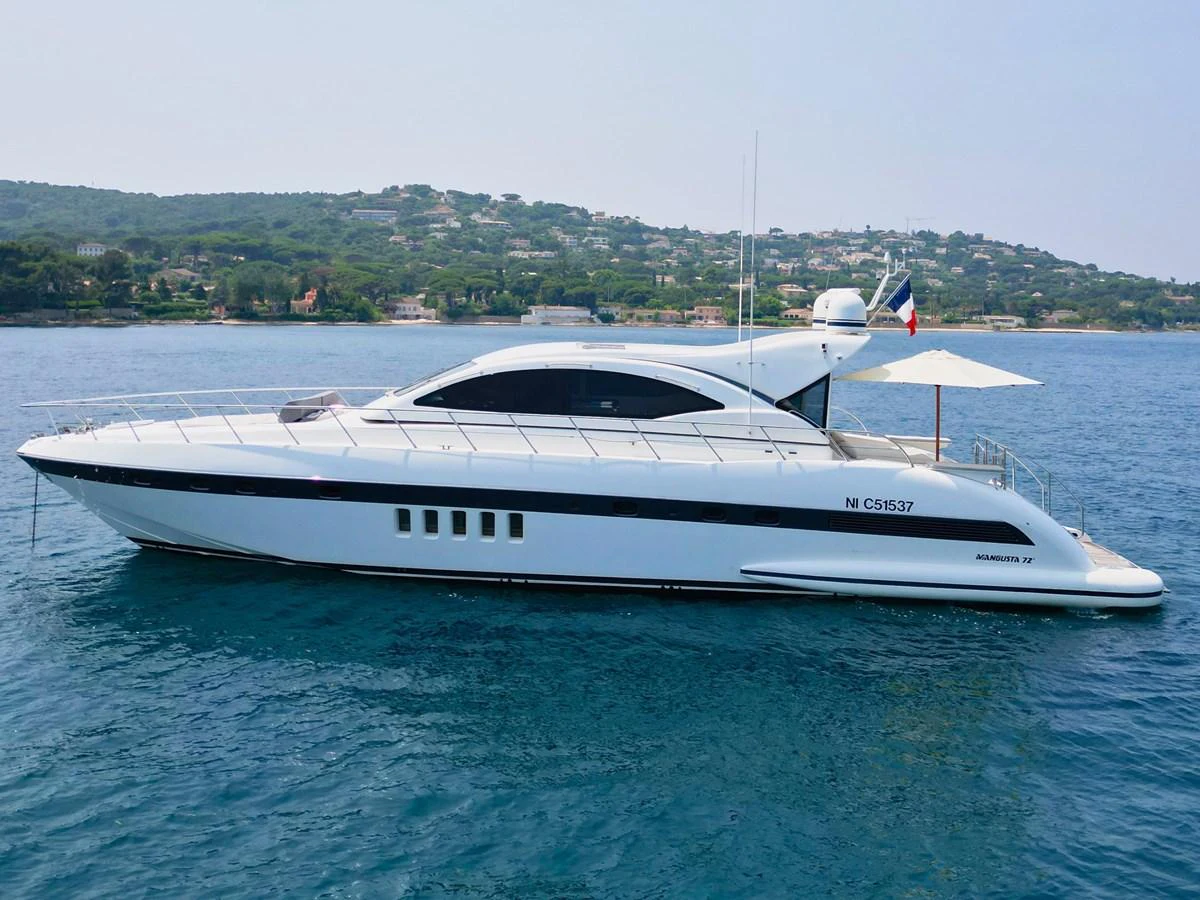 A sleek and modern yacht glides gracefully on calm waters with a scenic coastal backdrop. aboard CARO Yacht for Sale