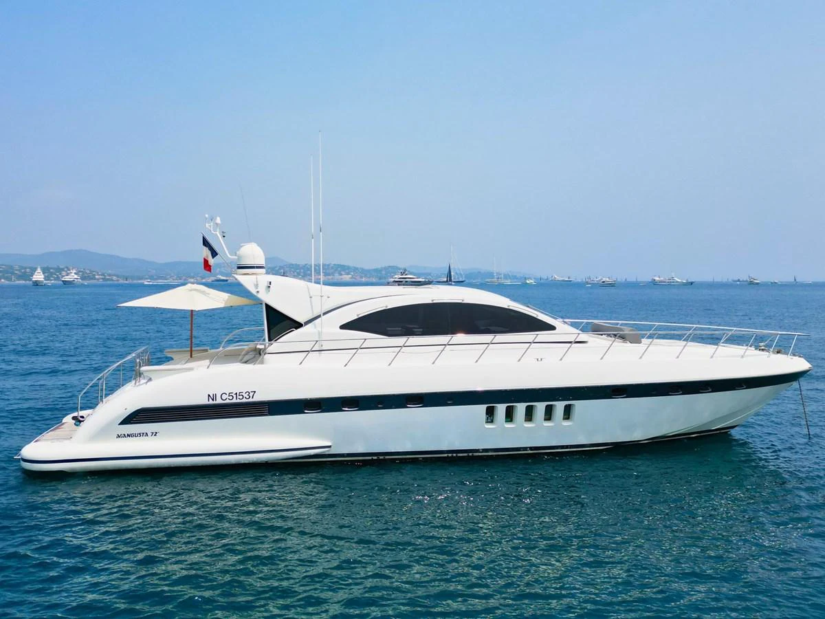 A sleek and modern yacht glides gracefully on calm blue waters under a clear sky. aboard CARO Yacht for Sale