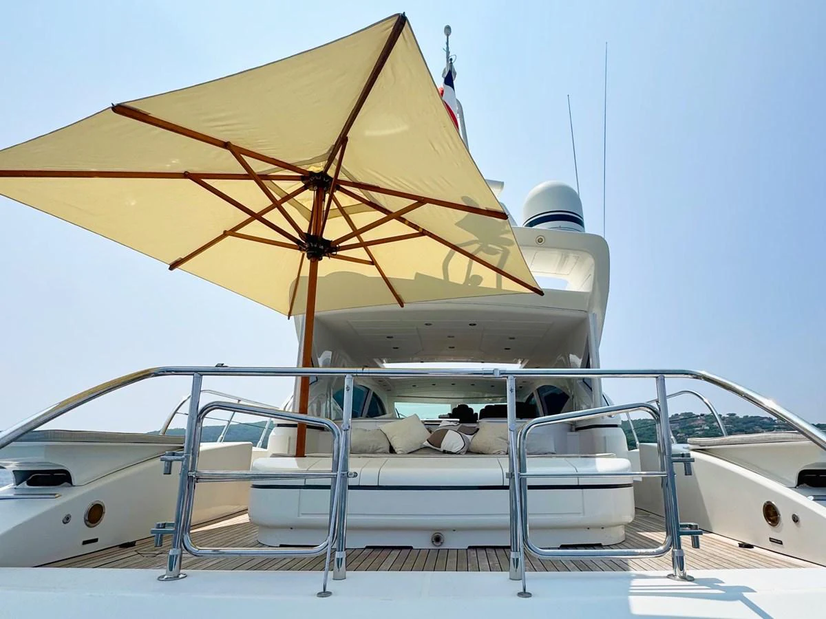 The aft deck features a spacious lounging area with a large umbrella providing shade. aboard CARO Yacht for Sale