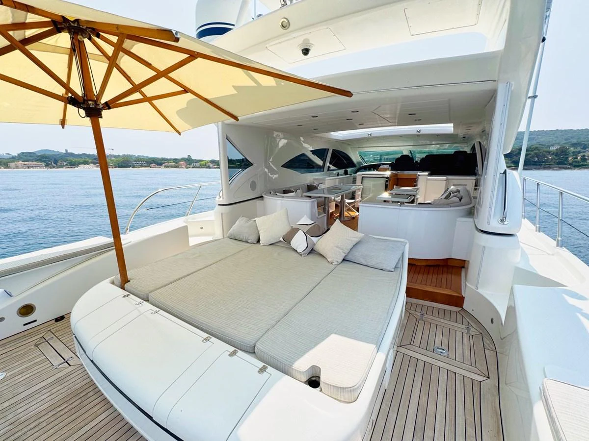 The aft deck features a spacious lounging area with plush cushions and a large umbrella for shade. aboard CARO Yacht for Sale